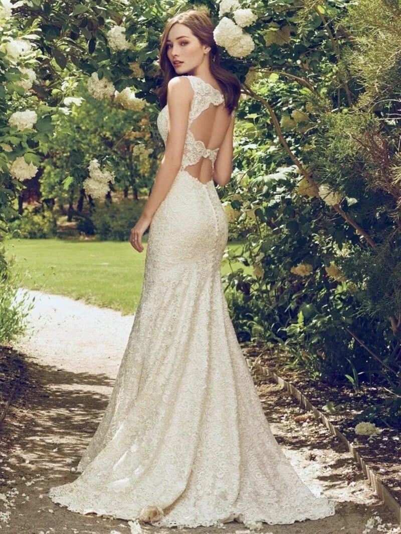 Bride in elegant lace wedding gown outdoors.