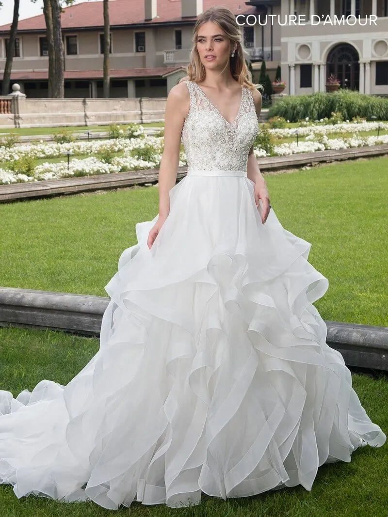 Bride in elegant white wedding gown outdoors.